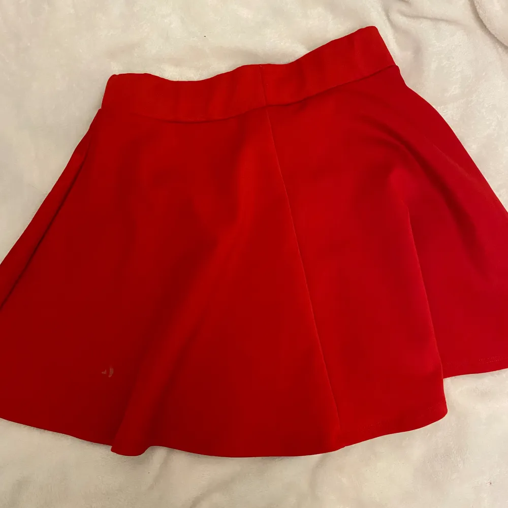 En fin röd kjol från Kappahl! Sälja p.g.a ingen andvändning och förliten. Har 2 fläckar men syns inte så mycket . Kjolar.