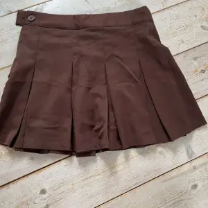 Brun kjol från H&M med dragkedja på sidan och knapp. Bra skick, säljs då den inte används.