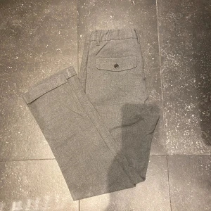 Gråa kostymbyxor  - Gråa kostymbyxor från Dressmann i storlek 29-30. Super fina och stilrena. Raka i modellen. Blev tyvärr försmå snabbt så knappt använda. Hör av er vid frågor!