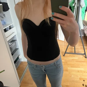 Svart korsett topp - En superfin svart korsett topp som går att ha till allt. Säljer eftersom att jag har många liknande. Materialet är väldigt stretchigt och går att justera i ryggen. 