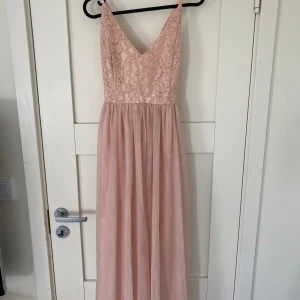 Balklänning / maxiklänning - Helt ny ljusrosa klänning av märket  ”Moments new york” men köpt på bubbelroom. Inköpt för ett par år sedan men aldrig använd. Justerbara band så går att anpassa själv.  storlek 40 men passar nog 38-42. Ordinariepris 1100 mitt pris 400