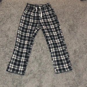 Pyjamas byxor  - Byxorna är mörkblå svart och vitt. Dom    är rutiga.