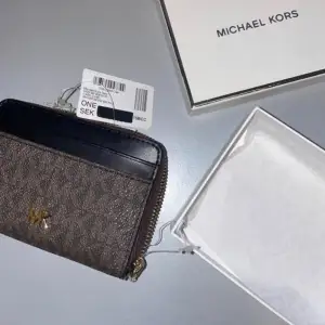 Helt ny oanvänd plånbok från Michel Kors. Brun och svart, prislapp kvar.