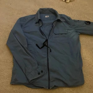 Cp company overshirt - Tjenare säljer en riktigt snygg cp company overshirt i bra skick. Inga defekter bara att det svarta bandet på dragkedjan har trasslat sig men det ser man p bilden. Priset är inte hugget i en sten. Passar bra på någon som är 165-170 ca!