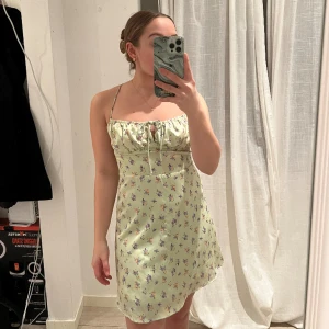 Blommig sommarklänning  - Super fin blommig klänning är ljusgrön färg. Ryggen är öppen med korsat band.  Använd ett fåtal gånger så i mycket bra skick. 