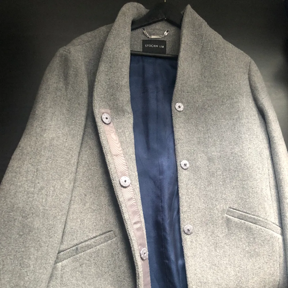 En grå lång kappa från STOCKH LM i storleken 38💗 använd men i bra skick, köparen står för frakten. Jackor.