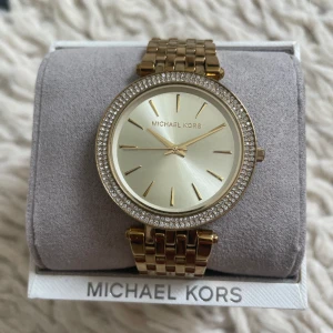 Michael Kors Darci klocka guld  - Väl omhändertagen och i mycket fint skick. Inga stenar saknas. En väldigt liten repa i glaset (se bild). Behöver batteribyte. Nypris 2695 kr. 