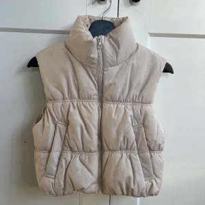 Croppad dunväst - Västen är i använt skick, den har sminkfläck som syns på bilden. De går säkert bort i tvätten då de är smink.