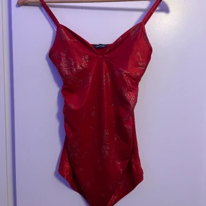 rött linne - jättefint rött linne med detaljer. materialet är väldigt skönt och den är lite längre fram än bak men kramar åt midjan fint. märke pimkie, nästan aldrig använd  