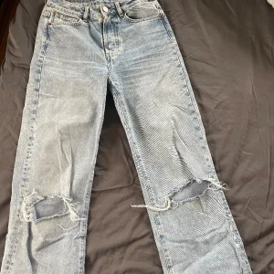 Ljusblåa jeans med hål på knäna - Super fina wide jeans med hål på knäna från BIKBOK i bra skickt! Strl 27