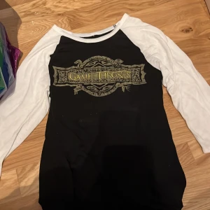 Game of Thrones tröja från Hot Topic - Game of thrones trekvarts ärmar tröja i lite tunnare tyg köpt på hot topic i USA! Inga fläckar eller något. Köparen står för frakten! Storlek S! Pris diskuteras!