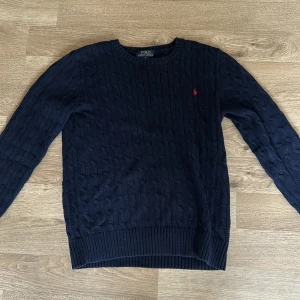 Stickad Ralph Lauren tröja - Riktigt snygg Ralph Lauren tröja.🙌 I nyskick förutom ett litet hål på axeln (syns ej vid användning). Därav det låga priset. Strl 16-18yr vilket motsvarar ca S/M Nypris ca 1400kr 