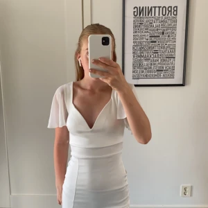 Vit klänning med slits - Klänningen är köpt på Zalando men säljs inte längre. Köptes förra året och är använd 1 gång på skolavslutningen. Den är stor i storleken så jag som vanligtvis har xs kan ha denna,köptes för 400kr. Inga defekter. Hör av er om ni är intresserade!💗