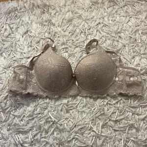 Beige push up bh - Beige push up bh, vet tyvärr inte storleken men skulle tro att den är runt 70/75B. Helt oanvänd!!!