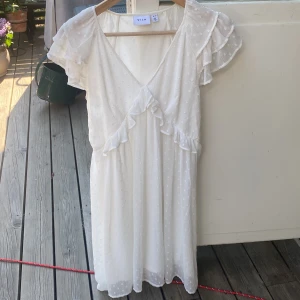 Vit sommarklänning - Vit sommarklänning som är perfekt till studenten💛💙 Använd 1 gång (på min studentmottagning). Slutar ovanför knäna på mig som är 169cm lång. 