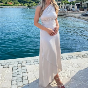 Champagne klänning - Säljer denna vackra klänning som jag endast använt 1 gång som bridesmaid. Superfin klänning i champagne färg.