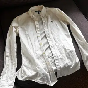 Fin skjorta från ralph lauren i vit/creme vit. Snygg och bra skick förutom en minimal missfärgning som knappt går att få med på bild under armarna . Syns inte vid användning! Storlek 6 på skjortan men uppskattar den som en Xs