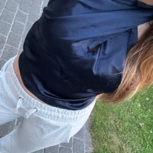 Satintopp marinblå - Hallu, jag säljer en marinblå jättefin fest topp från bikbok. Toppen är bara använd ett fåtal gånger och därav i väldigt gott skick. Fin design där toppen har band som man kan knyta en rosett i nacken och välja lite själv hur man vill ha den🤩💙