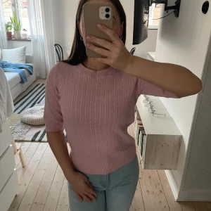 Rosa Kabelstickad tröja - Rosa kabelstickad tröja med trekvarts arm från Holly & Whyte by Lindex. I storlek XS, använd ett par gången, inget slitage eller fläckar. 