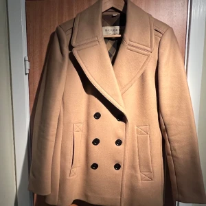 Burberry jacka - Jättesnygg klassisk ulljacka m dubbelknäppning. Inköpt i Italien, äkta, i strlk IT42 vilket motsvarar ungefär 38-40. Använd ca 3 ggr o säljs pga att den tyvärr känns lite liten.  Nypris ca 12 000 kr