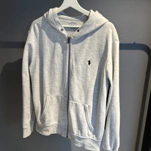 En grå polo Ralph fluoren zip hoodie  Knappt använd  Ny pris 2000 Skick 9/10