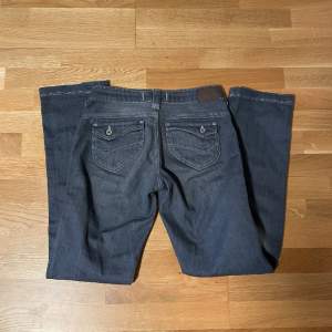 Raka jeans med knappar på fickorna, smått slitna vid botten. midja: 35.cm innerbenslängd: 82cm, är långa på mig som är 165cm
