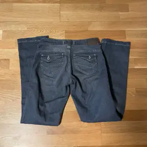 Raka jeans med knappar på fickorna, smått slitna vid botten. midja: 35.cm innerbenslängd: 82cm, är långa på mig som är 165cm