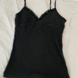 Vintage bershka linne - Svart linne med spets detalj från vintage Bershka. Köpt på Vinted men i bra skick! Kommer tyvärr inte till användning av mig så säljer det här 😊💕