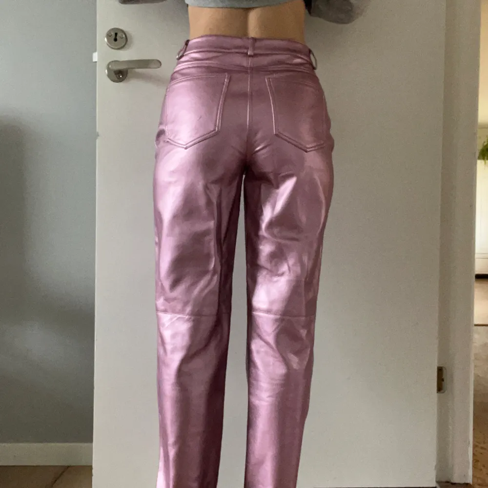 Coola läderbyxor i rosa metallic Använda fåtal gånger, jättebra skick  Normala i storleken. Har raka ben och är höga i midjan.  Perfekta till fest nu i vår och sommar!!. Jeans & Byxor.