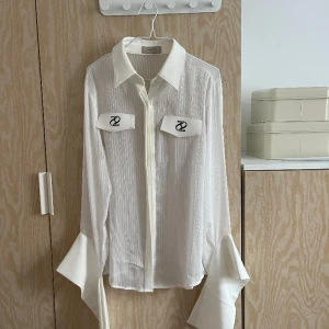 Skjorta med detaljer  - Skjorta från Two twice med detaljer på. Långa armsr som hänger ner för cool effekt samt märket på fickorna. Aldrig använd så i bra skick. Nypris 3000kr 