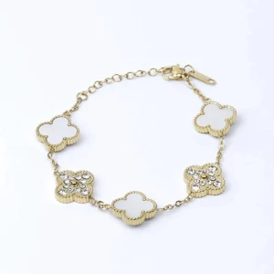 Fyrklöver armband - Så snyggt fyrklöver armband i 18k äkta Guld Pläterat på rostfritt stål. Armbandet är försedd med dubbelriktade fyrklöver, på ena sidan är det vita stenar och på andra är det strålande strass-stenar. En Sten är lite annorlunda men inget man tänker på