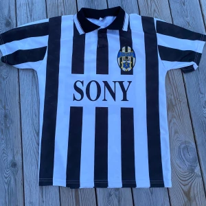 Juventus del Piero t-shirt! - Tja, säljer denna riktigt unika Juventus fotbollstshirt med del Piero på ryggen! Tröjan är från 1990 talet. Tyvärr så finns det inget som kan intyga att den är äkta. Skicket är okej, finns dock 2 små hål i ena armvecket och ett annat nära kragen.