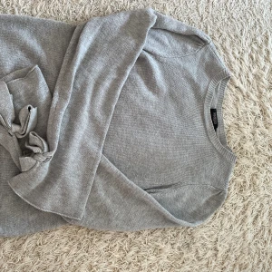 Stickad tröja - Fin stickad tröja mer avtagbara band i ärmarna som man knyter rosetter med 🎀