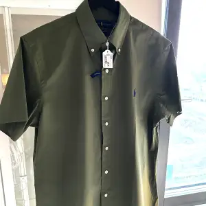 Kortärmad grön tunn oanvänd Ralph Lauren skjorta, perfekt till sommaren! Väldigt luftig o tunn i materialet! Stl M med custom fit 💚