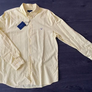 NY skjorta Gant - Storlek 176, motsvarar en S. Mått på bilder. Supersnygg gul färg, så himla fräscht till sommaren! Lappen kvar, aldrig använd. 