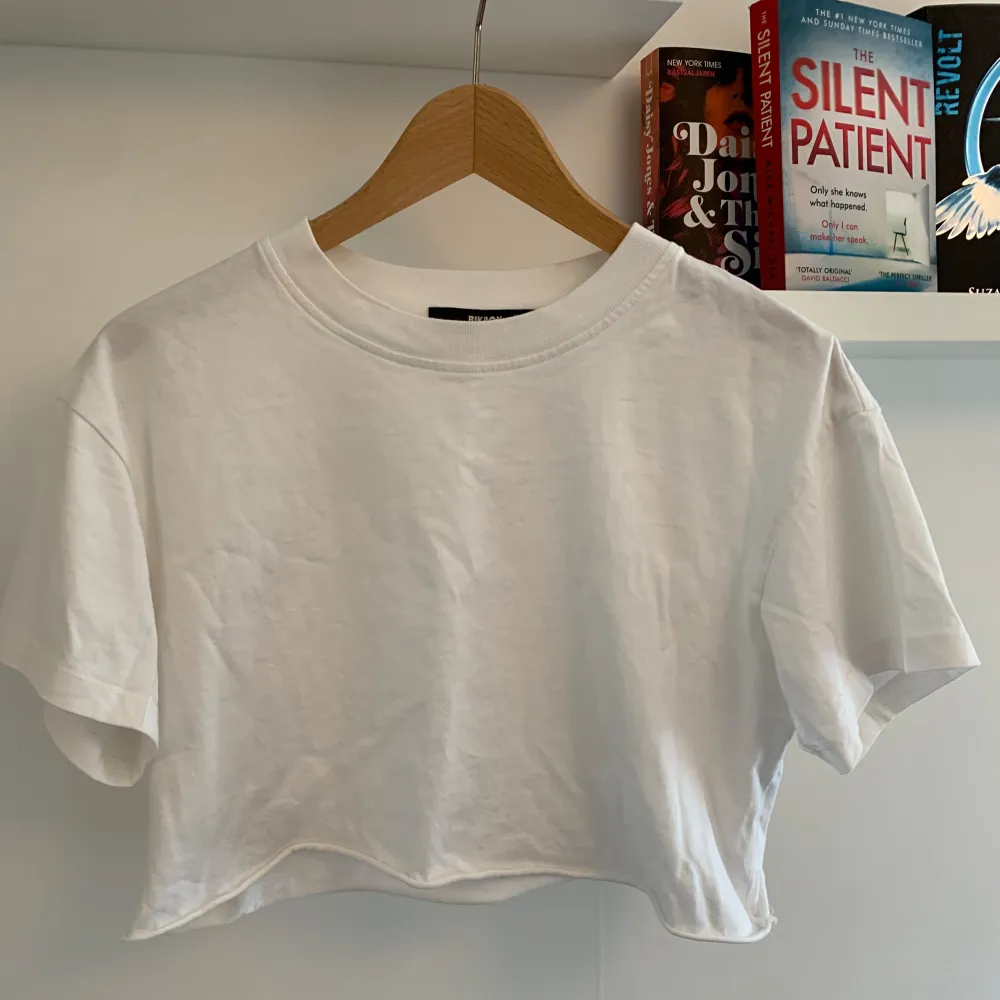Vit croppad tshirt med avklippt look från bikbok🤍 storlek S men passar både större och mindre! Använd fåtal gånger och mycket fint skick . T-shirts.
