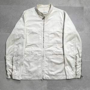 Off white färgad bomulls jacka i moto-jacket stil från Martin Margielas SS2004 kollektion. I fint skick men med lite slitage vid ärmsluten. 