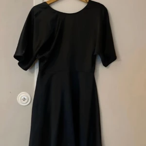 Svart kort klänning med öppen rygg - Normal i storleken