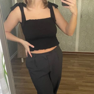 Svart linne - Ett jättefint svart linne med justerbara knytband i axlarna🌺 Inköpt på ginatricot, i storlek s men är i ett stretchigt material så skulle säga att en xs och en m också kan ha den! Kommer inte till användning längre och därför säljer jag den. 