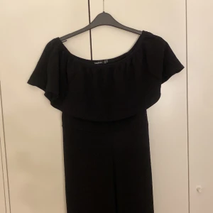  Jumpsuit - Storlek L, en lång jumpsuit med ett tyg på som ser ut som en fin topp. Den har kommit till användning 2 gånger. Sitter fint på kroppen och strechbar. 