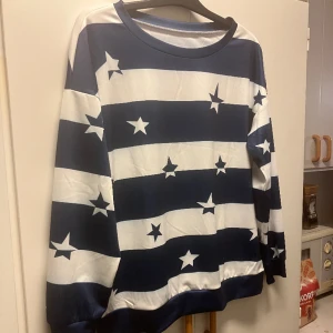 Blå/vif tröja med stjärnor - Den är helt nyköpt och har bara tesfats. Storlek är L. 95% polyester och 5% spandex.
