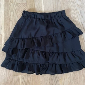 Svart volangkjol - Minikjol med volanger från NAKD. Fint skick!