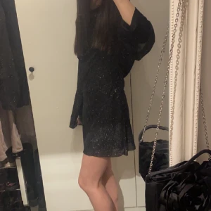 Klänning med öppen rygg - Svart glittrig klänning med öppen rygg, aldrig använd💘