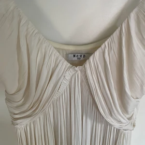 Vit Långklänning från NA-KD - Säljer min gamla balklänning från 2021, den passar exempelvis superbra att ha på sin mottagning ifall det skulle vara så att man snart tar studenten 😍👌 Jättefint fall och elegant 🌟 Enbart använd en gång! Storlek 36 men passar som 38 också.