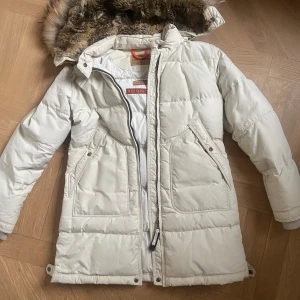 Parajumpers Long Bear  - Säljer en äkta PJS jacka i barnstorlek L som passar XS/S. Jackan är ljust beige/off white. Äkta pälskrage.  *Läs bion innan ni skriver till/handlar hos mig.