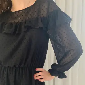 En svart kort prickig långärmad klänning i mesh med volang över axlarna, framtill och nedtill samt resår i midjan och vid ärmslut från H&M i strl XS!💓 