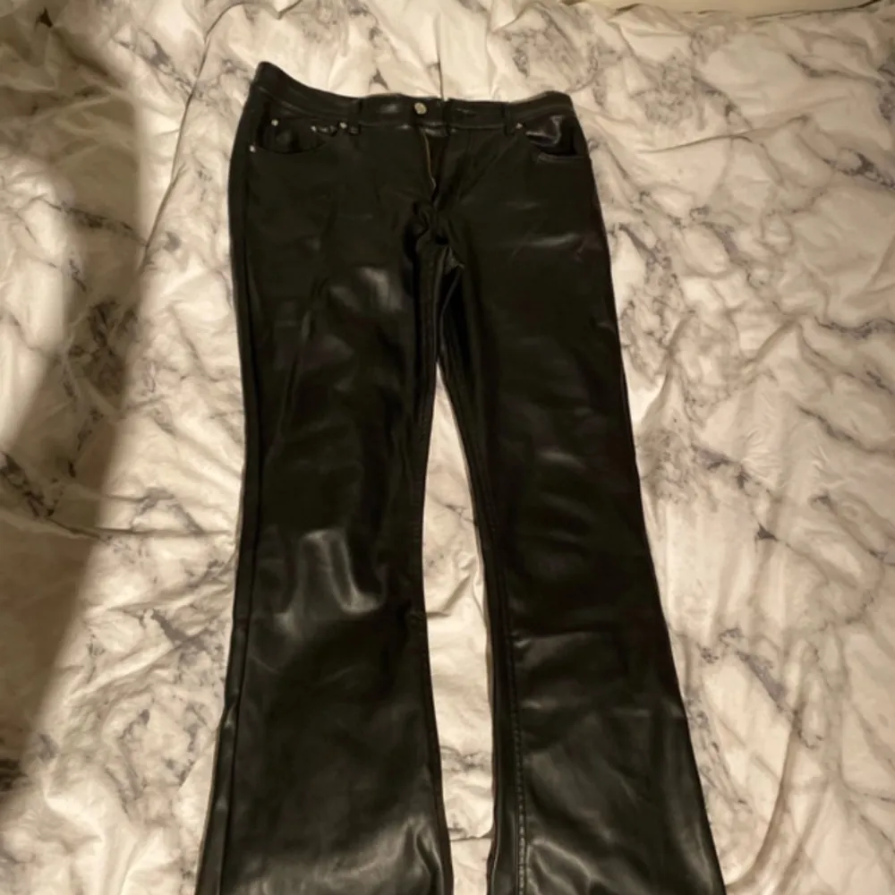 Bootcut byxor i skinn imitation från Gina tricot, mid/low waist, storlek 42, använda fåtal gånger. Jeans & Byxor.