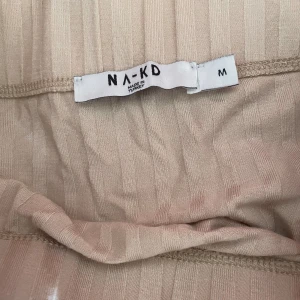 Na-kd beige kjol - En beige midi kjol med slit från Na-kd. Helt nytt skick men ingen prislapp.