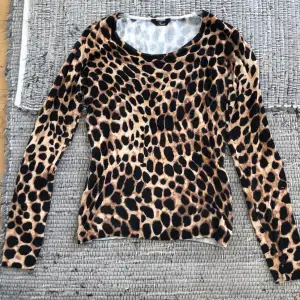 Långärmad tröja med leopard print. Skulle tro att storleken är ungefär L men Passar fint som en off one shouldertröja för mig som ofta bär XS