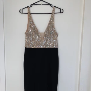Kvälls klänning  - En lång kvälls/ball klänning i perfekt skick! Beige topp med silvriga detaljer på och svarta delen under. 